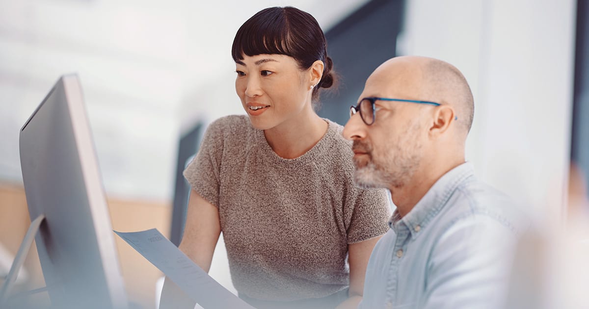 How AI-enabled BPaaS supports banking operations Two colleagues working together at a computer